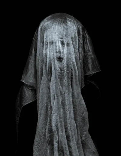 Portrait spectral d’un visage à travers un voile translucide, éclairage minimaliste.